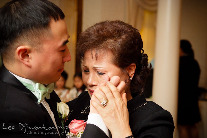 Mother of groom crying while doing mother and son dance. Groom wiping of tears from mother's eyes. Ceresville Mansion Frederick Maryland Wedding Photo by wedding photographer Leo Dj Photography